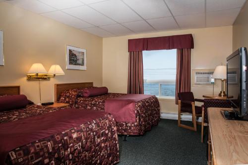 Cow Head浅湾汽车旅馆&小屋会议中心的酒店客房设有两张床和电视。