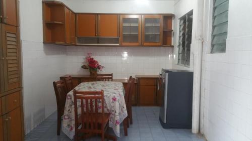 山打根GuestHouse Taman Megah, Lot 19的小厨房配有桌椅和冰箱。