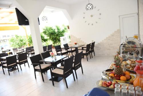 乌尔齐尼Apartments Cota Guesthouse的用餐室配有桌椅和水果展示
