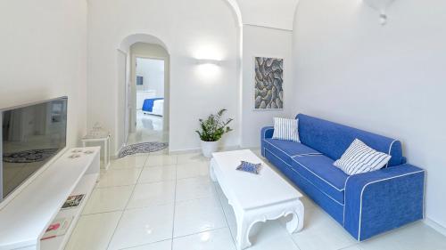 伊斯基亚Exclusive Home Ischia的客厅配有蓝色的沙发和桌子