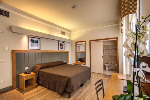 佛罗伦萨德拉纳泽欧尼酒店的卧室配有一张床和一张桌子