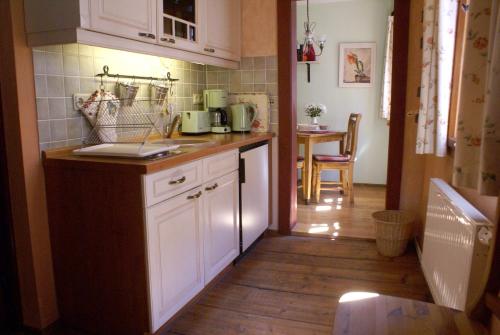 奎德林堡思胡霍夫公寓的厨房铺有木地板,配有白色橱柜。