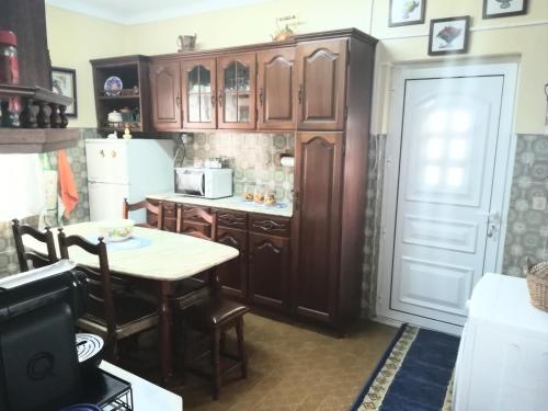 贝尔蒙特Casa Rafael的厨房配有木制橱柜、桌子和冰箱。