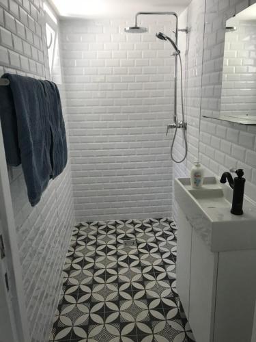 鲍洛通塞迈什Balatonszemes small House的白色浴室铺有黑白色瓷砖地板。