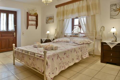 伊兹拉Kassandra House的一间卧室配有一张带粉色床单和枕头的床。