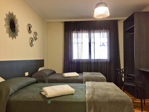 阿尔苏阿De Camino vivienda de uso turístico的客房设有两张床和窗户。