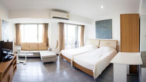 清迈加拉里通塔公寓式酒店的一间卧室配有一张床、一张沙发和一台电视。