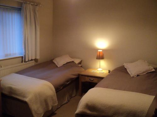 斯托克波特梅普尔旅馆的一张桌子上灯的房间里两张床铺