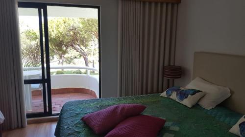 金塔湖Victory Village Club, Quinta do Lago的一间卧室配有带枕头的床铺和阳台