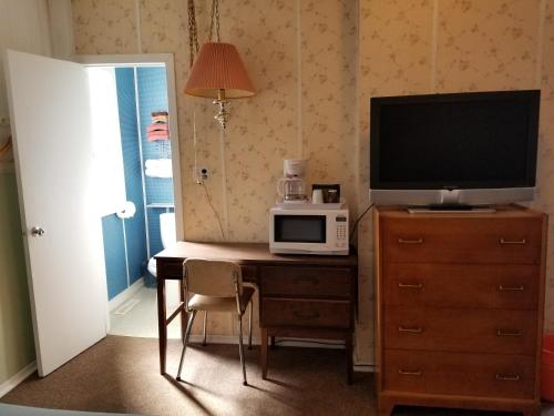 MelvilleMelsask Motel的客房设有书桌、电视和微波炉。