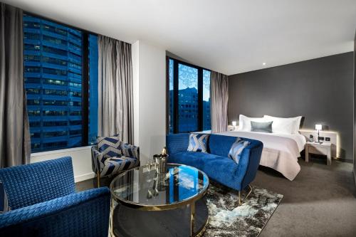 珀斯墨尔本酒店的酒店客房配有一张特大号床和蓝色椅子