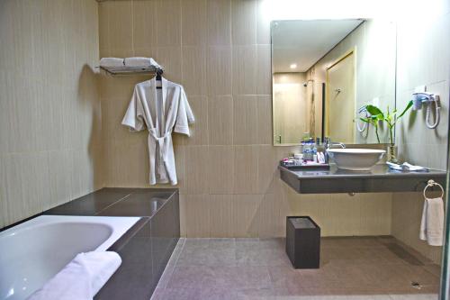 茂物帕加加兰套房度假及会议酒店的带浴缸、水槽和镜子的浴室
