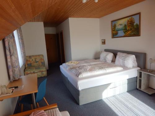 法克湖奥塔度假宾馆的一间卧室配有一张床、一张桌子和一把椅子