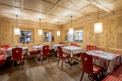 拉瓦莱珀斯塔佩蒂鲁亚酒店的餐厅拥有木墙和桌子以及红色椅子