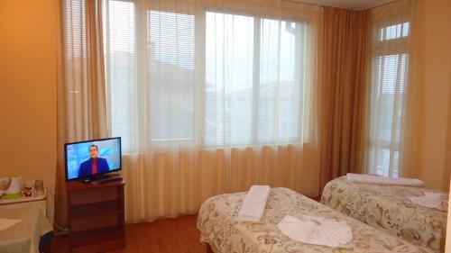 布尔加斯Matev Hotel的酒店客房设有两张床和电视。