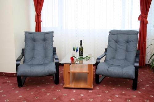 克勒拉希克勒拉希酒店的两把椅子和一张桌子及一瓶葡萄酒