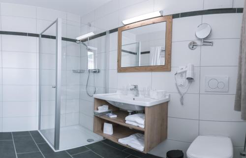 埃兴Bierhotel - Hotel & Brauereigasthof Schneider的一间带水槽、淋浴和镜子的浴室