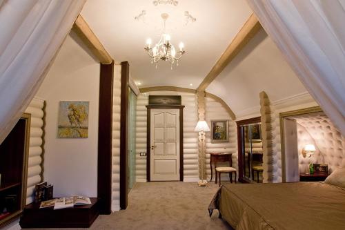FilippovichiЗагородный отельно-ресторанный комплекс "Четыре сезона"的一间卧室配有一张大床和一个吊灯。