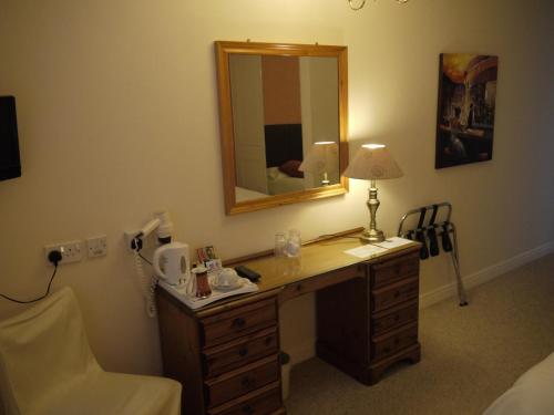 Barnby Dun洛奇旅馆的客房设有带镜子和灯的书桌。