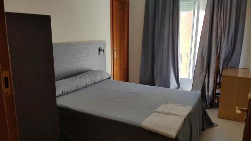塔兰孔艾斯塔希翁旅馆的一间卧室设有一张床和一个窗口