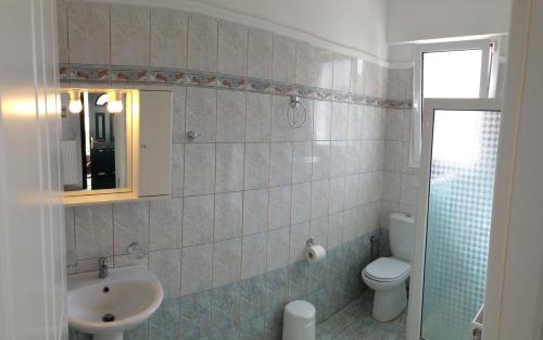 苏卡雷斯Esperia Studios的一间带水槽、卫生间和镜子的浴室