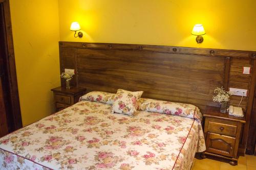 索托德坎加斯康洪托帕塞拉酒店的一间卧室配有一张带木制床头板的床