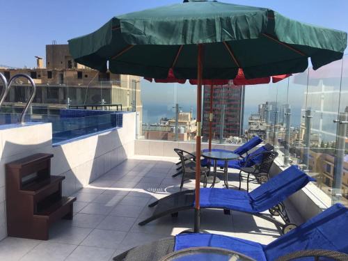 贝鲁特Midtown Hotel & Suites的庭院配有桌椅和遮阳伞。