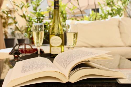 勒芒夏尔乐敦酒店的一张桌子上的开放式书,上面放着酒杯