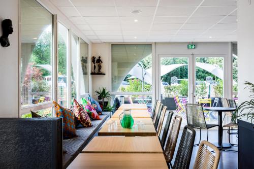 安格雷Kyriad Anglet - Biarritz的一间带长桌和椅子的用餐室