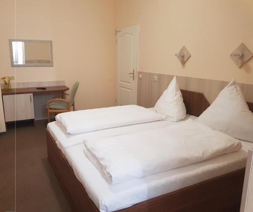 纽伦堡艾姆贝特膳食公寓酒店的一间卧室配有两张带白色床单的床
