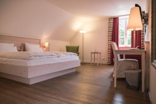 埃兴Landhotel - Hotel & Brauereigasthof Schneider的配有一张床和一张书桌的酒店客房