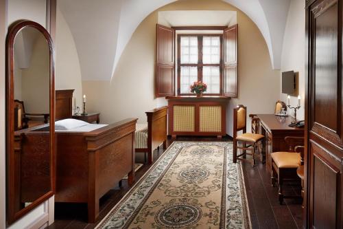 明斯克明斯克市中心莫娜四提凯酒店的一间卧室配有一张床、一张书桌和一个窗户。