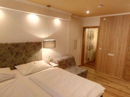 克拉根福瓦豪旅馆的一间卧室配有一张床、一把椅子和一盏灯