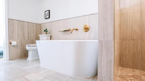 华盛顿莱恩DC酒店的浴室配有白色浴缸和卫生间。