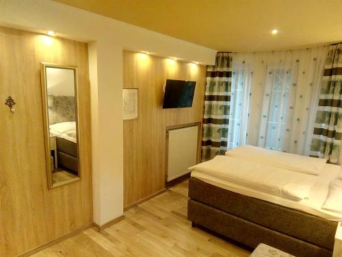 克拉根福瓦豪旅馆的一间小卧室,配有一张床和镜子