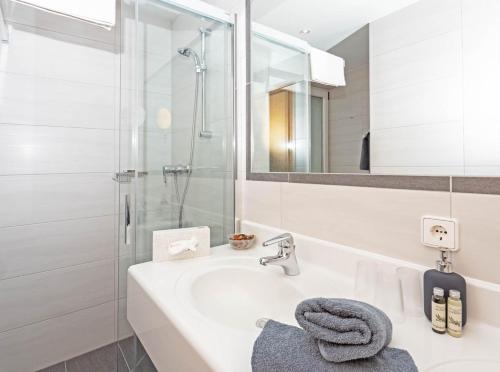 魏森湖Wiesenhof, Hotel direkt am See的白色的浴室设有水槽和淋浴。