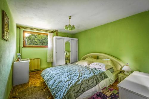 PodmelecApartment Blaž的绿色卧室设有床和窗户