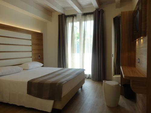 巴多利诺Bio Suites PACINOTTI的酒店客房设有一张床和一个大窗户