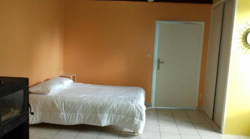 LouplandeLocation 24 heures du Mans的卧室配有白色的床和橙色的墙壁