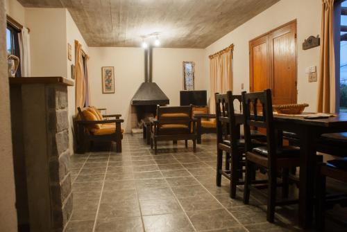 拉帕洛马Casas de la Paloma - BUTIA的客厅配有桌椅和壁炉