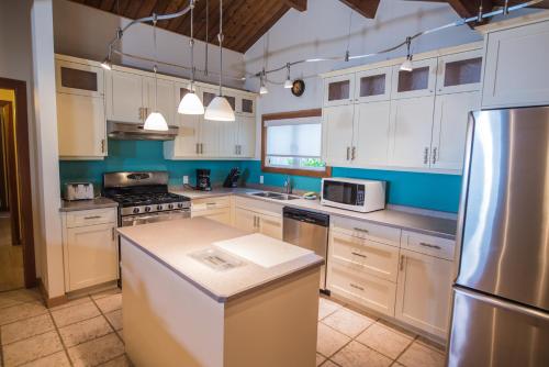 Oyster Bay海洋度假酒店的厨房配有白色橱柜和不锈钢用具