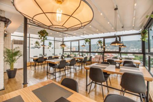 第比利斯木材精品酒店的餐厅设有桌椅和窗户。