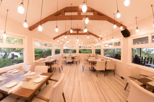 下博克特芬卡莱里达咖啡种植园和精品酒店的用餐室设有桌椅和窗户。