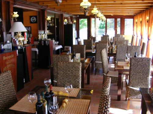 希欧福克Hermina Panzió的餐厅配有桌椅和葡萄酒瓶