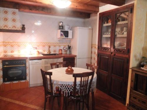 莫斯克鲁埃拉戈麦斯度假屋的厨房配有桌椅和冰箱。