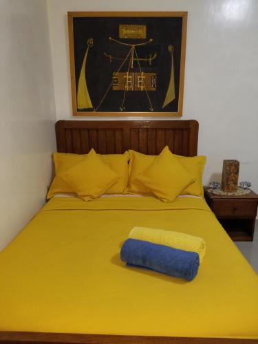 达喀尔Studio Confort Fann Hock的黄色的床,上面有蓝色的毛巾