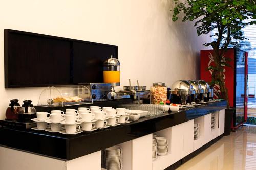 万隆亚玛瑞斯赛汉姆佩勒斯酒店的一条带白杯和盘子的自助餐线