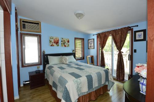 斯特拉福德Ambassador B&B Guest Home的一间拥有蓝色墙壁的卧室、一张床和窗户