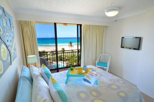 黄金海岸Blue Ocean Apartment的一间卧室配有一张床,享有海滩美景