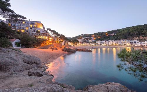 塔马留Hotel Hostalillo的享有海滩的夜间美景,设有建筑